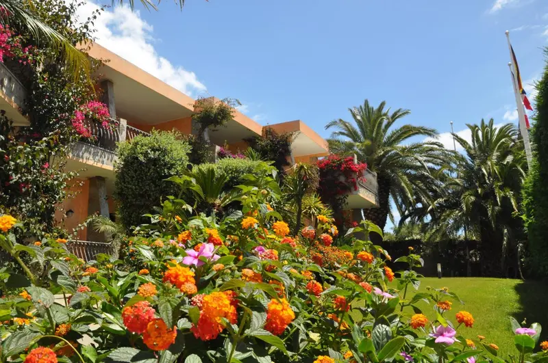 Bâtiment coloré orné de fleurs et de végétation tropicale sous un ciel bleu.
