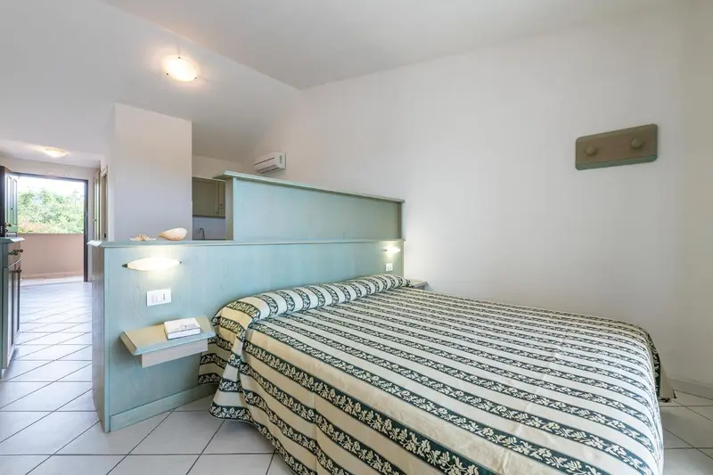 Une chambre lumineuse avec un grand lit et un accès à une terrasse.