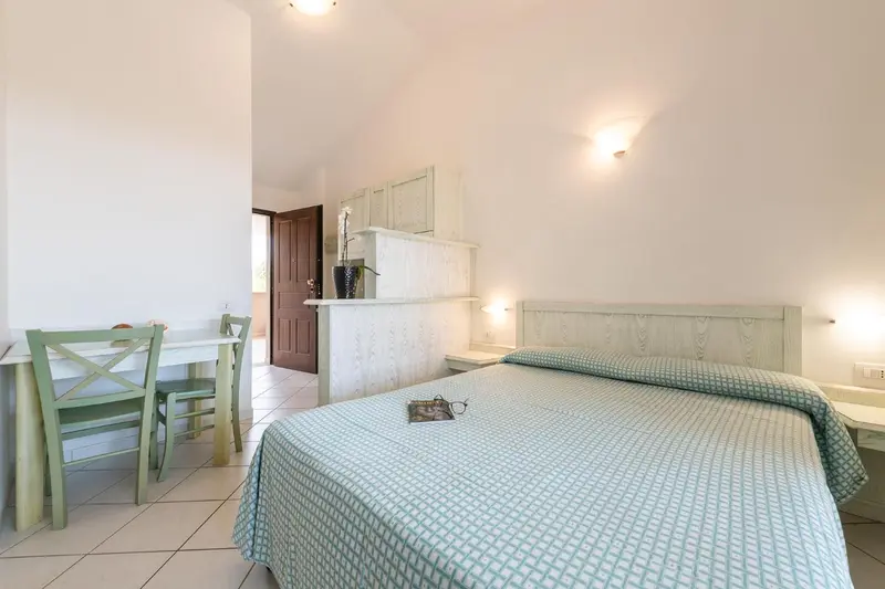 Une chambre lumineuse avec un lit et un coin repas.