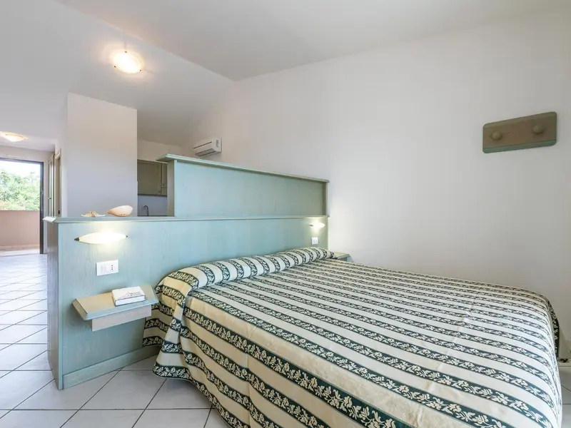 Une chambre lumineuse avec un grand lit recouvert d'une courtepointe à motifs.