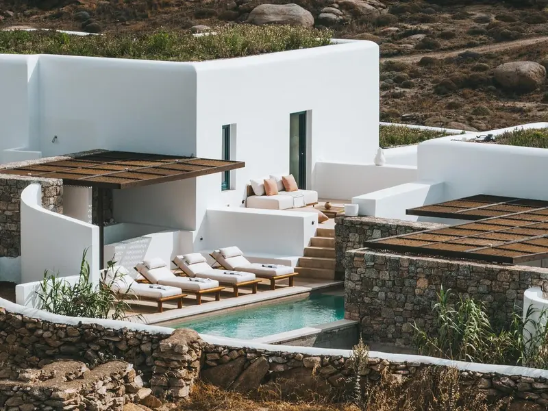 Terrasse aménagée avec des chaises longues et une petite piscine.