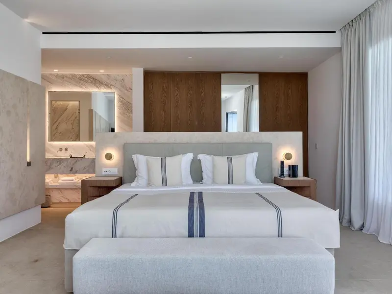 Une chambre lumineuse avec un grand lit et un décor moderne.