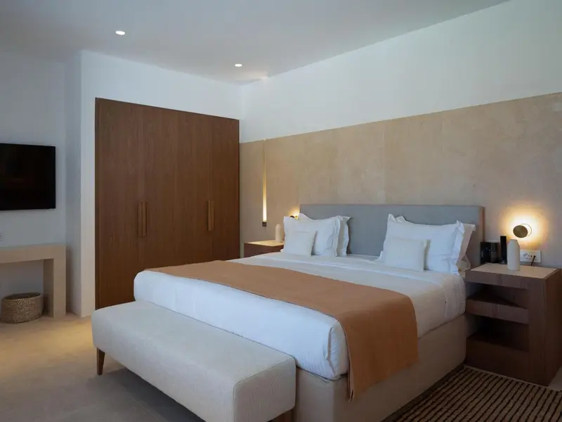 Une chambre lumineuse avec un grand lit et un espace détente.