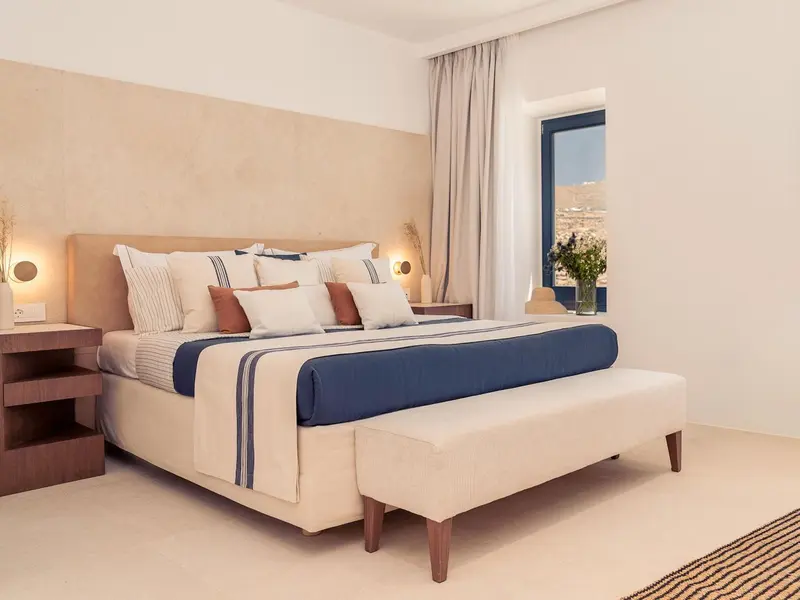 Une chambre lumineuse avec un grand lit et une décoration sobre.
