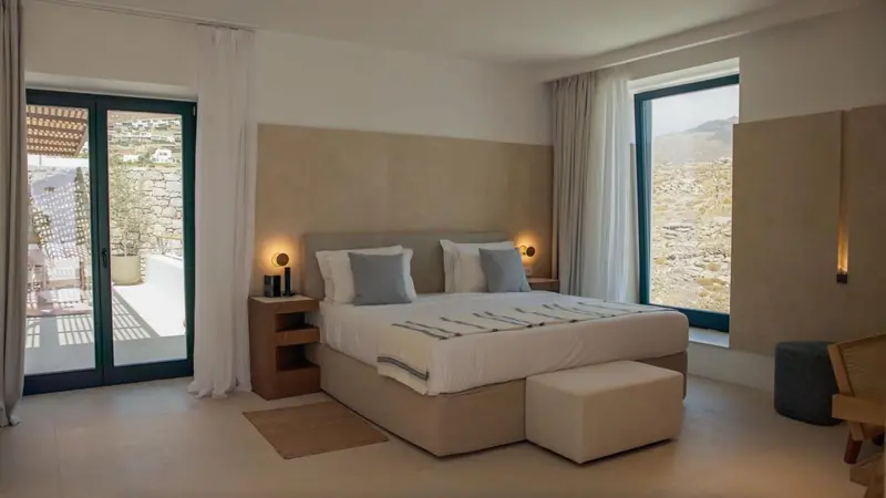 Une chambre lumineuse avec un grand lit et une vue sur le paysage.