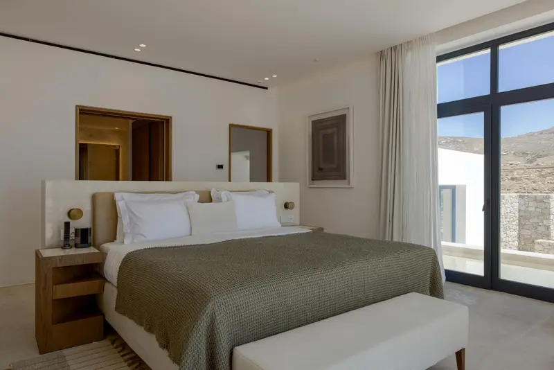 Une chambre lumineuse avec un grand lit et une vue sur un paysage montagneux.
