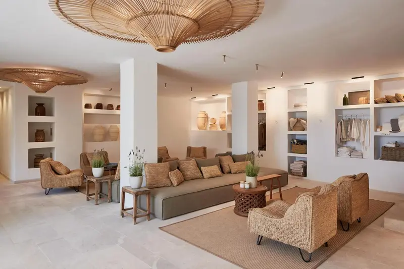 Espace de détente intérieur avec canapés et luminaires en rotin.