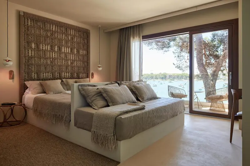 Une chambre lumineuse avec un grand lit et vue sur la mer.