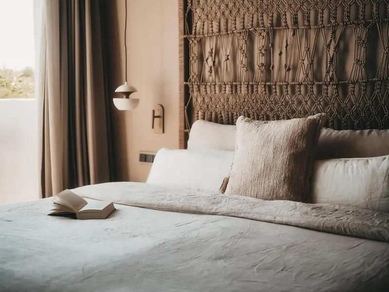 Un lit confortable avec des oreillers moelleux et un livre ouvert sur la couverture.