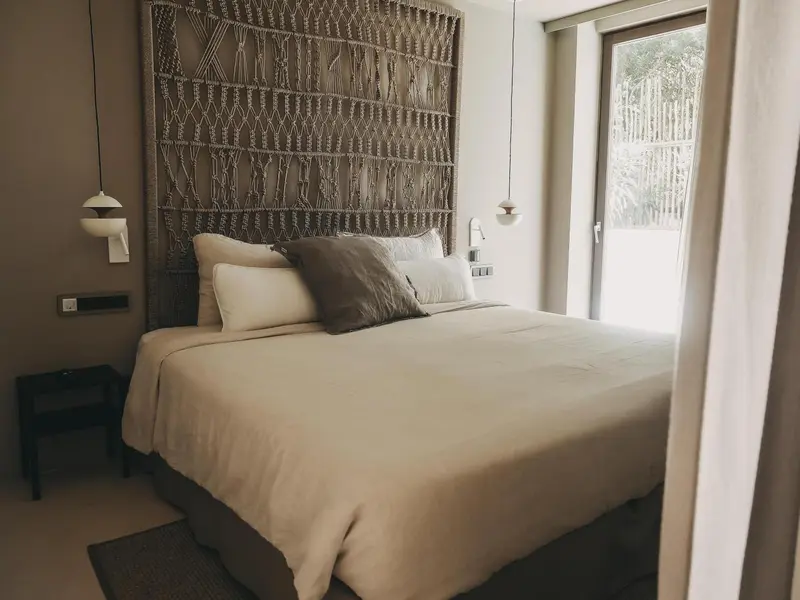 Une chambre à coucher lumineuse avec un grand lit recouvert de linge blanc.