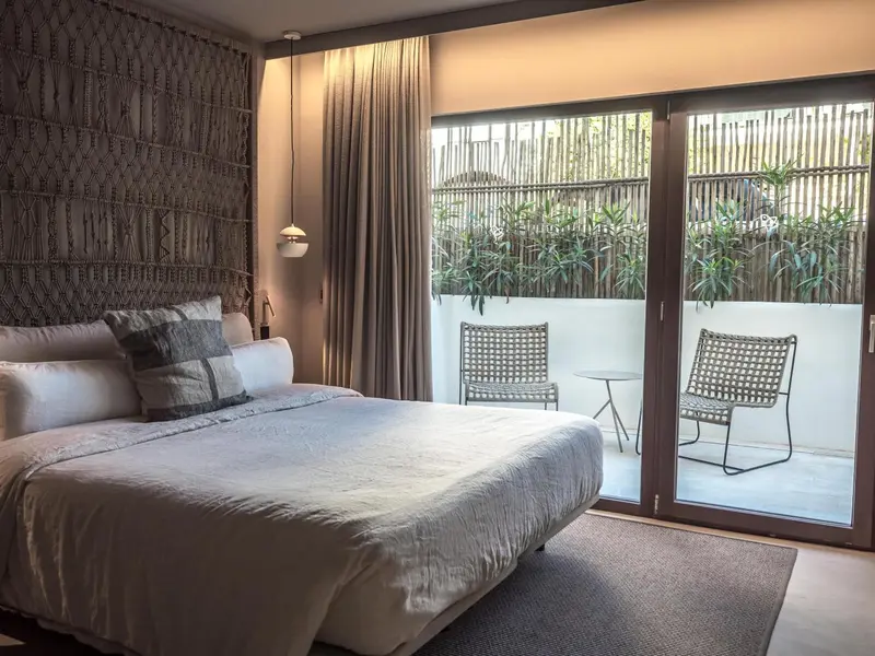 Une chambre lumineuse avec un grand lit et un accès à une terrasse.