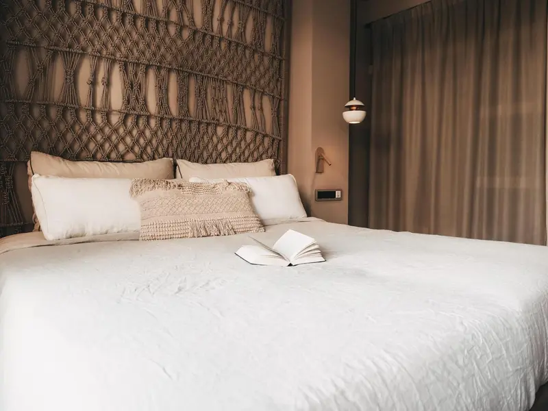 Un lit confortable avec des oreillers moelleux dans une chambre décorée.