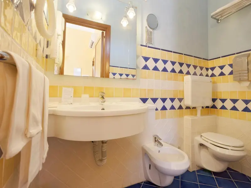 Une salle de bain lumineuse avec des carreaux de céramique colorés.