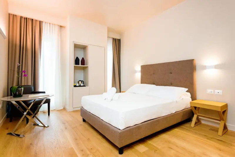 Une chambre lumineuse avec un grand lit et un coin salon.