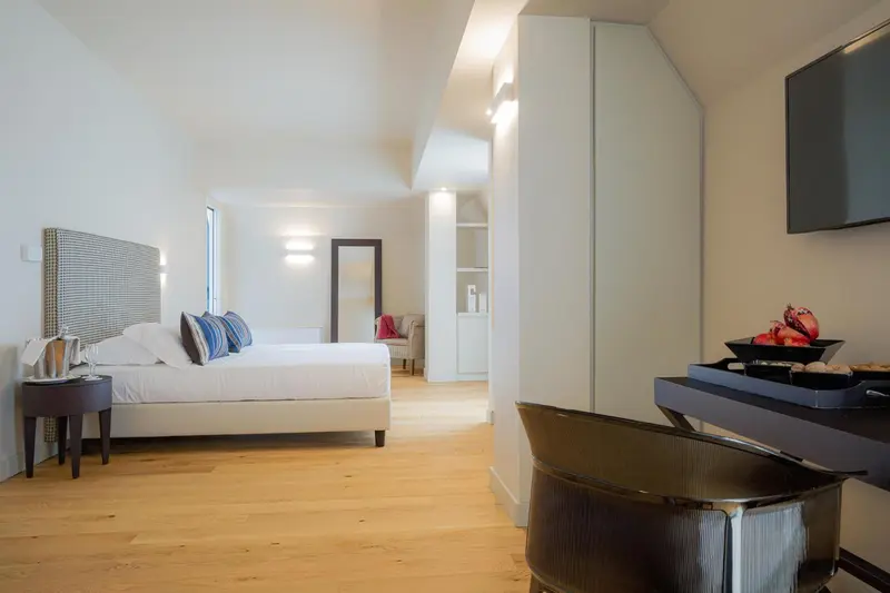 Une chambre lumineuse avec un grand lit et un plateau de fruits.