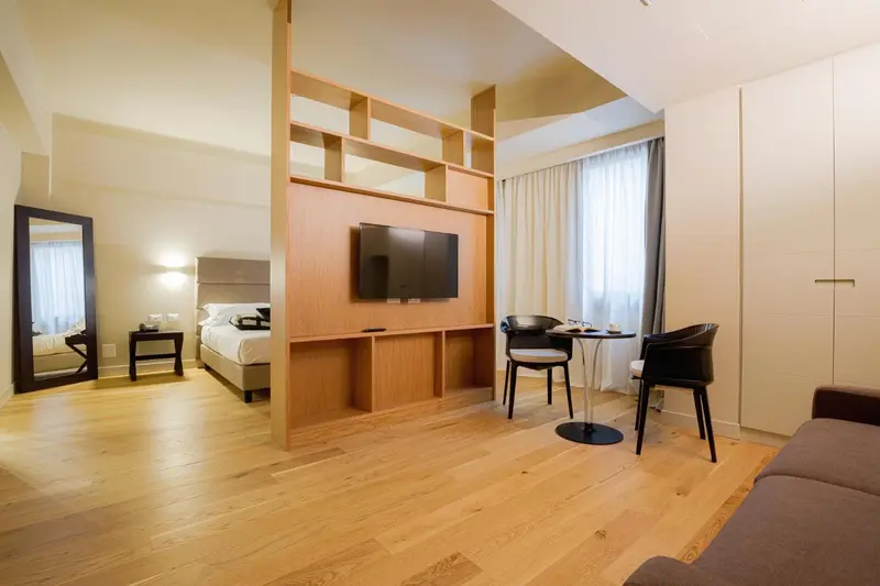 Espace de vie lumineux avec un coin repas et un lit en arrière-plan.