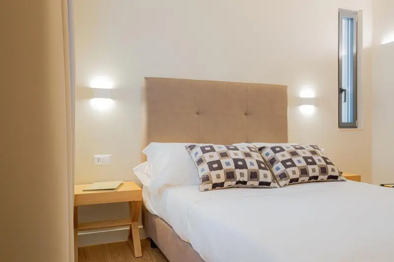 Une chambre lumineuse avec un grand lit recouvert d'une courtepointe.