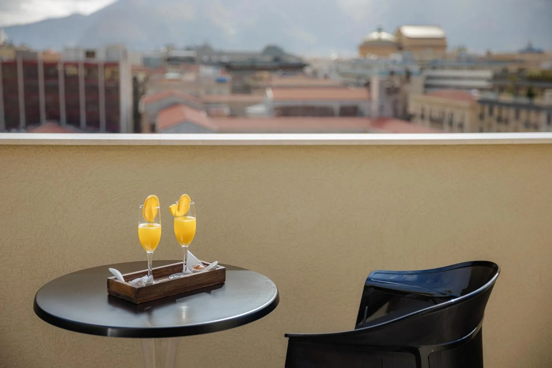 Deux verres de jus d'orange sur une table ronde sur une terrasse.