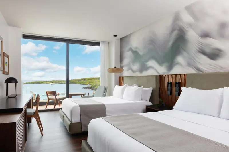 Une chambre lumineuse avec un grand lit et une vue sur la mer.