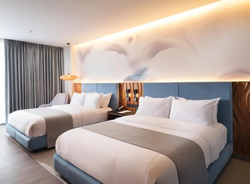 Une chambre moderne avec deux lits simples et une décoration murale abstraite.