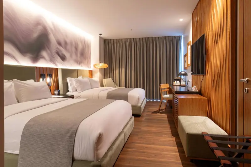 Chambre moderne avec deux lits et un bureau en bois.