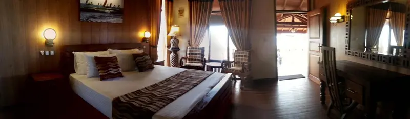 Une chambre spacieuse avec un grand lit et un coin salon.