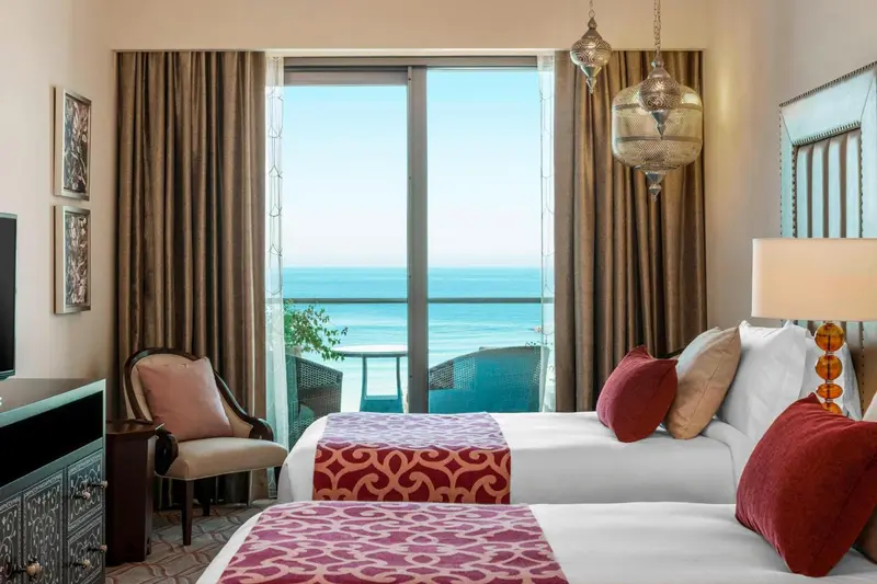 Chambre avec vue sur la mer depuis un balcon.