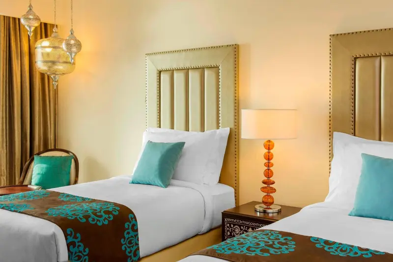 Une chambre d'hôtel avec deux lits simples et une décoration soignée.