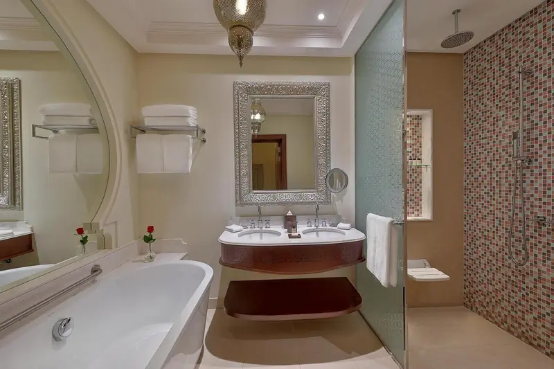 Une salle de bain lumineuse avec une baignoire et une double vasque.
