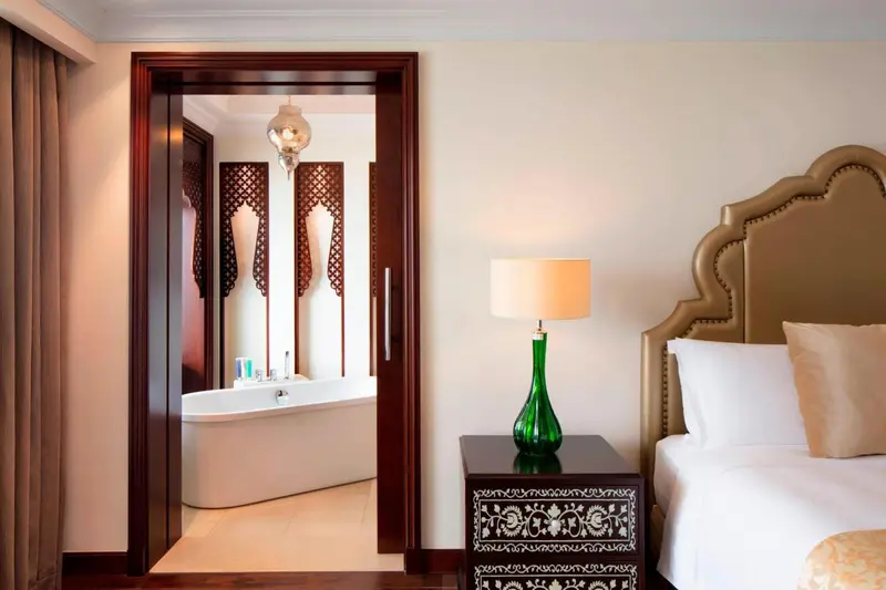 Une chambre à coucher lumineuse avec un lit et un accès à une salle de bain.