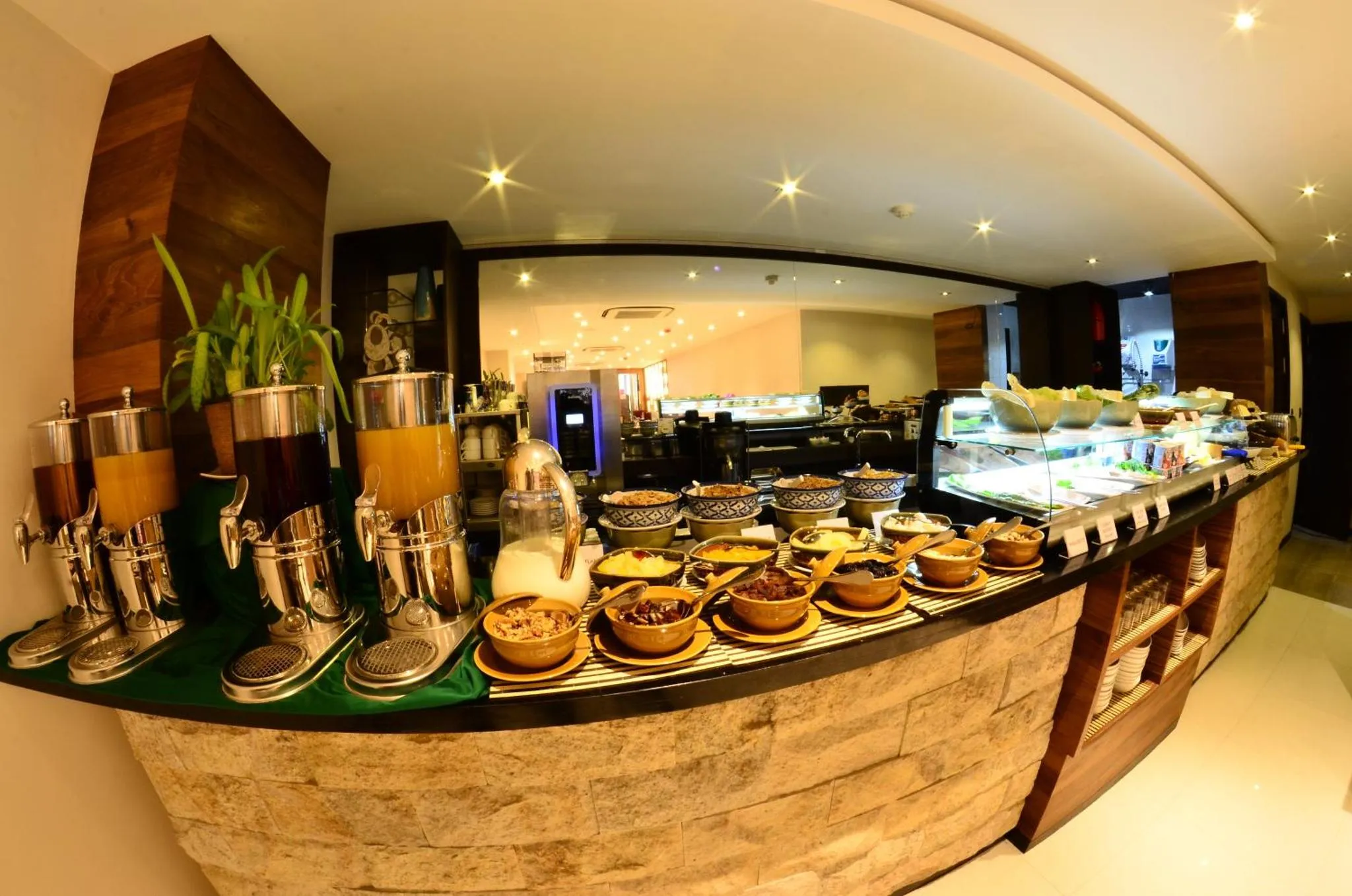 Un buffet propose une variété de plats et de boissons dans un espace lumineux.
