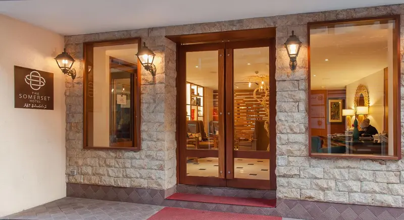 Entree d'un hotel avec un hall d'accueil visible a travers des portes vitrees.