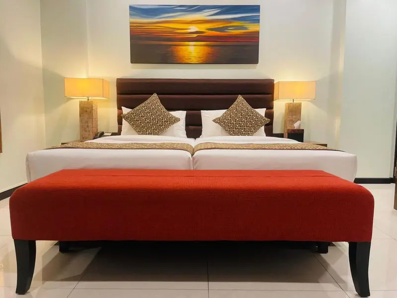 Une chambre avec un grand lit et une décoration murale.
