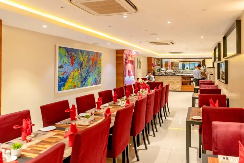 Une salle de restaurant lumineuse avec des tables dressées pour le service.