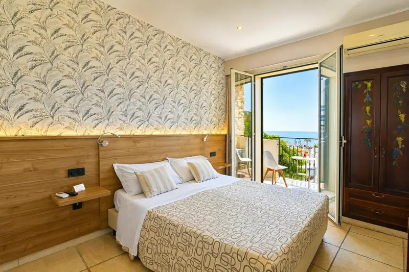 Une chambre lumineuse avec un lit double et un accès à un balcon.