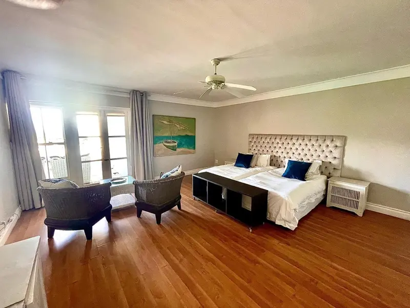 Une chambre lumineuse avec un grand lit et un coin salon.