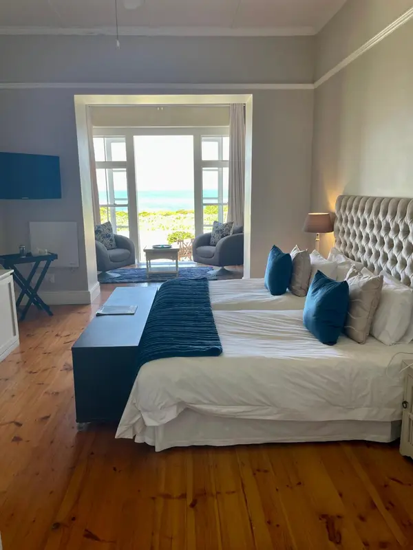 Une chambre lumineuse avec un grand lit et vue sur la mer.
