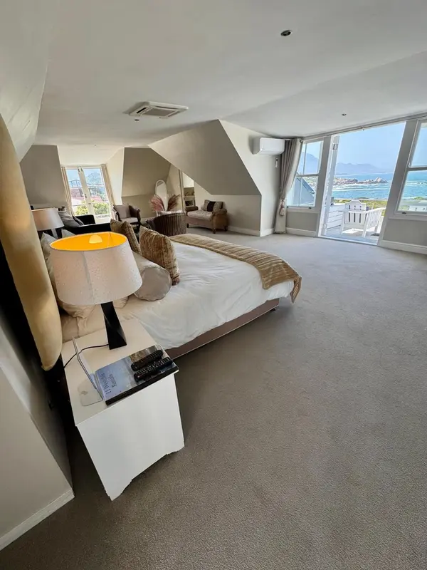Une chambre lumineuse avec un grand lit et une vue sur la mer.