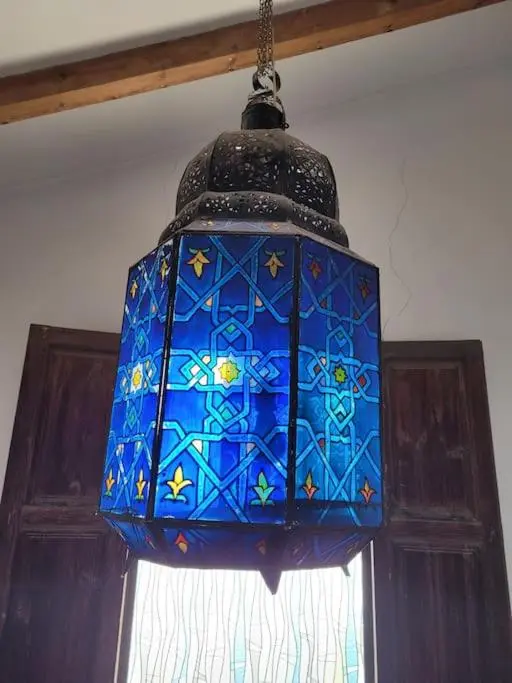 Suspension décorative en métal et vitrail bleu.