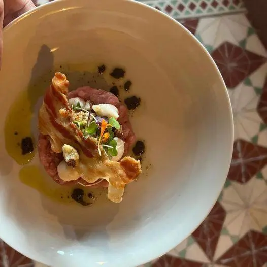 Assiette présentée avec une préparation culinaire raffinée.