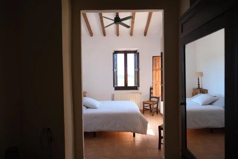 Une chambre lumineuse avec deux lits simples et une fenêtre.