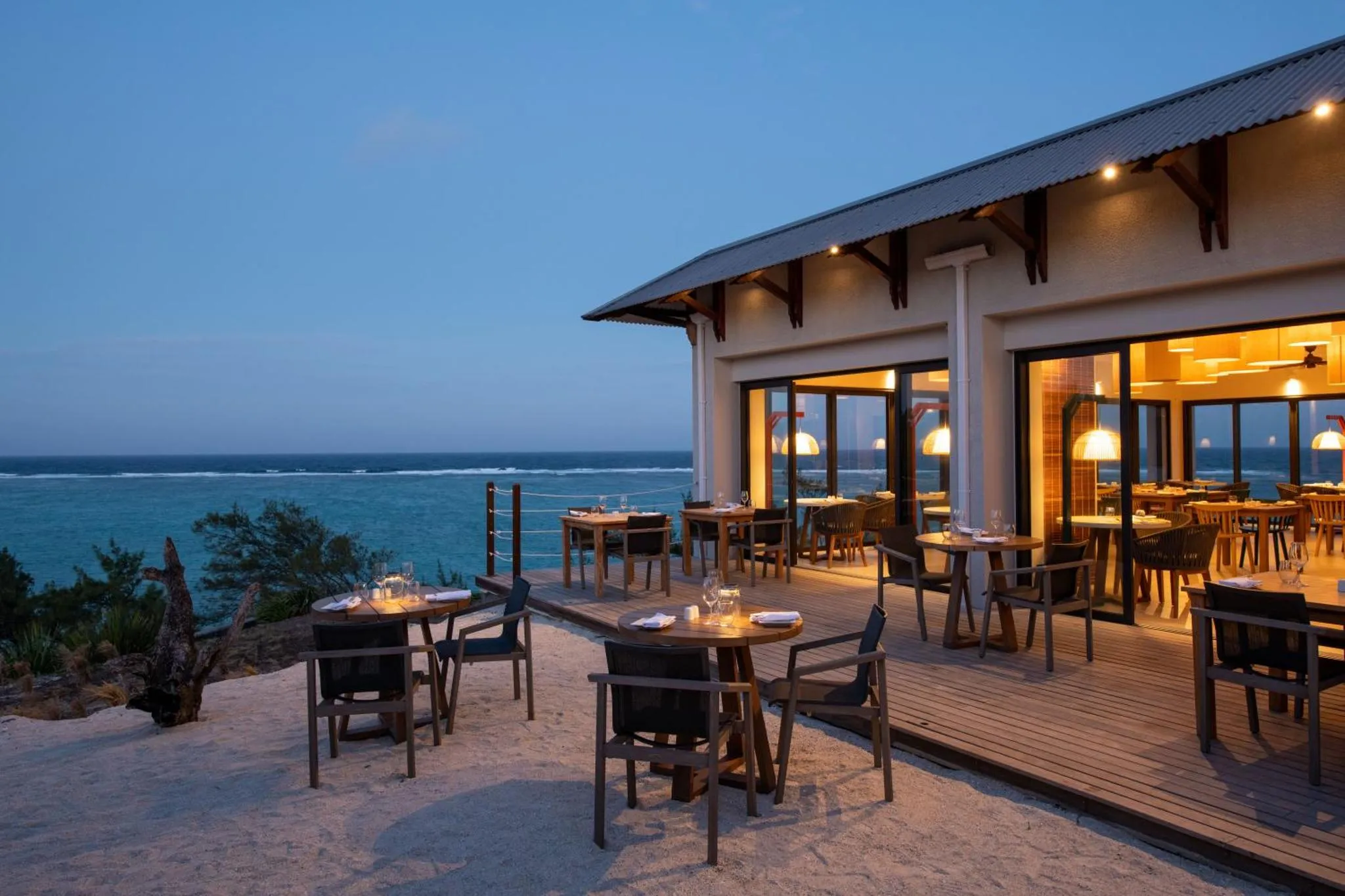 Terrasse de restaurant en bord de mer au crépuscule.