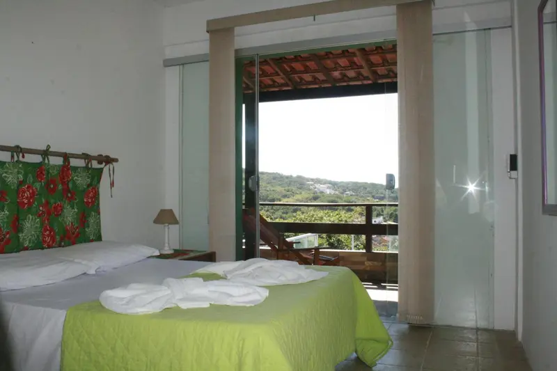 Une chambre lumineuse donne sur une vue verdoyante.
