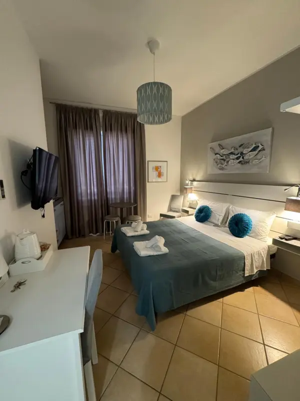 Une chambre lumineuse avec un grand lit et un bureau.
