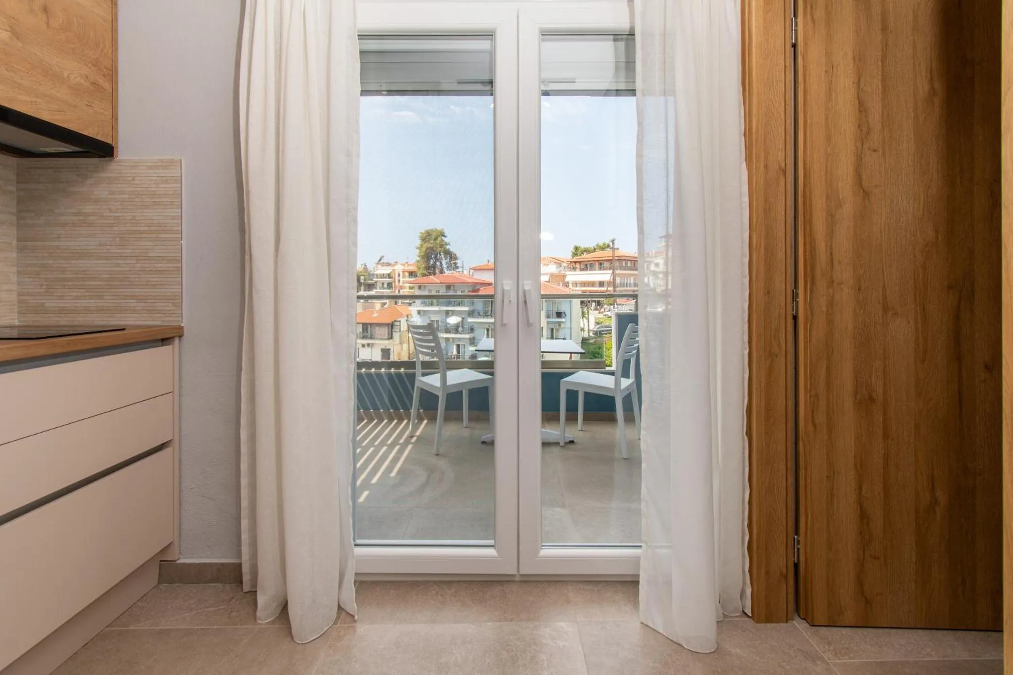Vue sur une terrasse depuis un intérieur clair et moderne.