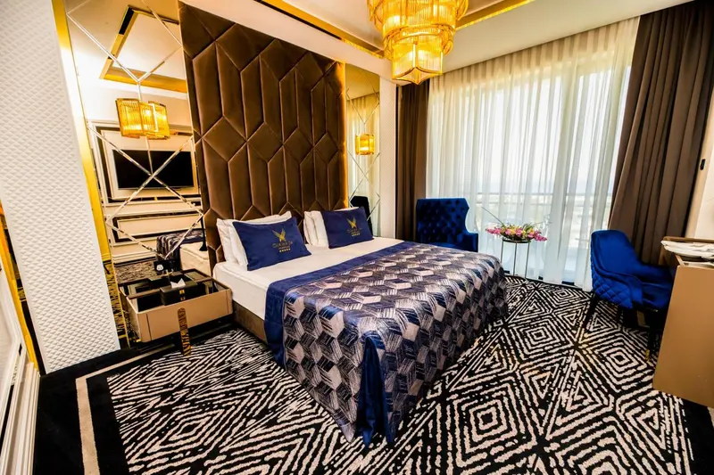 Une chambre d'hotel avec un grand lit recouvert d'une courtepointe bleue et blanche.