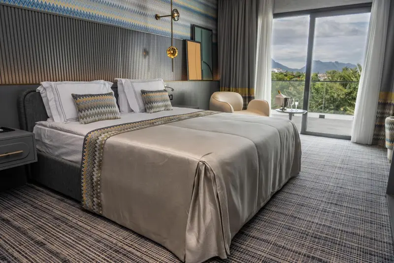Une chambre moderne avec un grand lit et une vue sur un paysage montagneux.