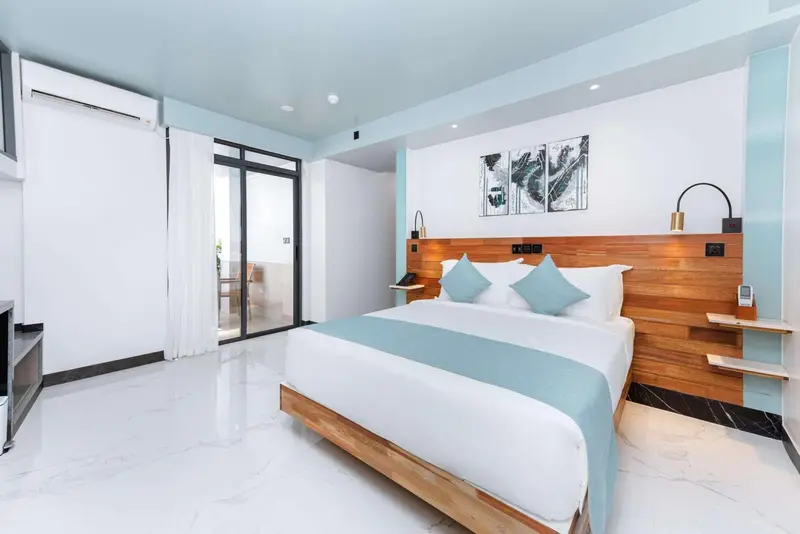Une chambre lumineuse avec un grand lit et un décor moderne.