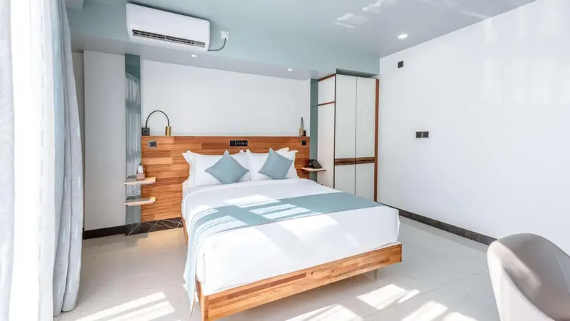 Une chambre lumineuse avec un grand lit et un mobilier en bois.