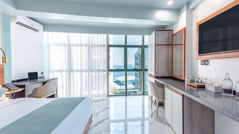 Une chambre lumineuse avec un grand lit et une vue sur la mer.